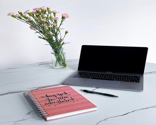 A clean professional lifestyle workplace showing a notebook and bottle of pure water signifying structural habits and focus